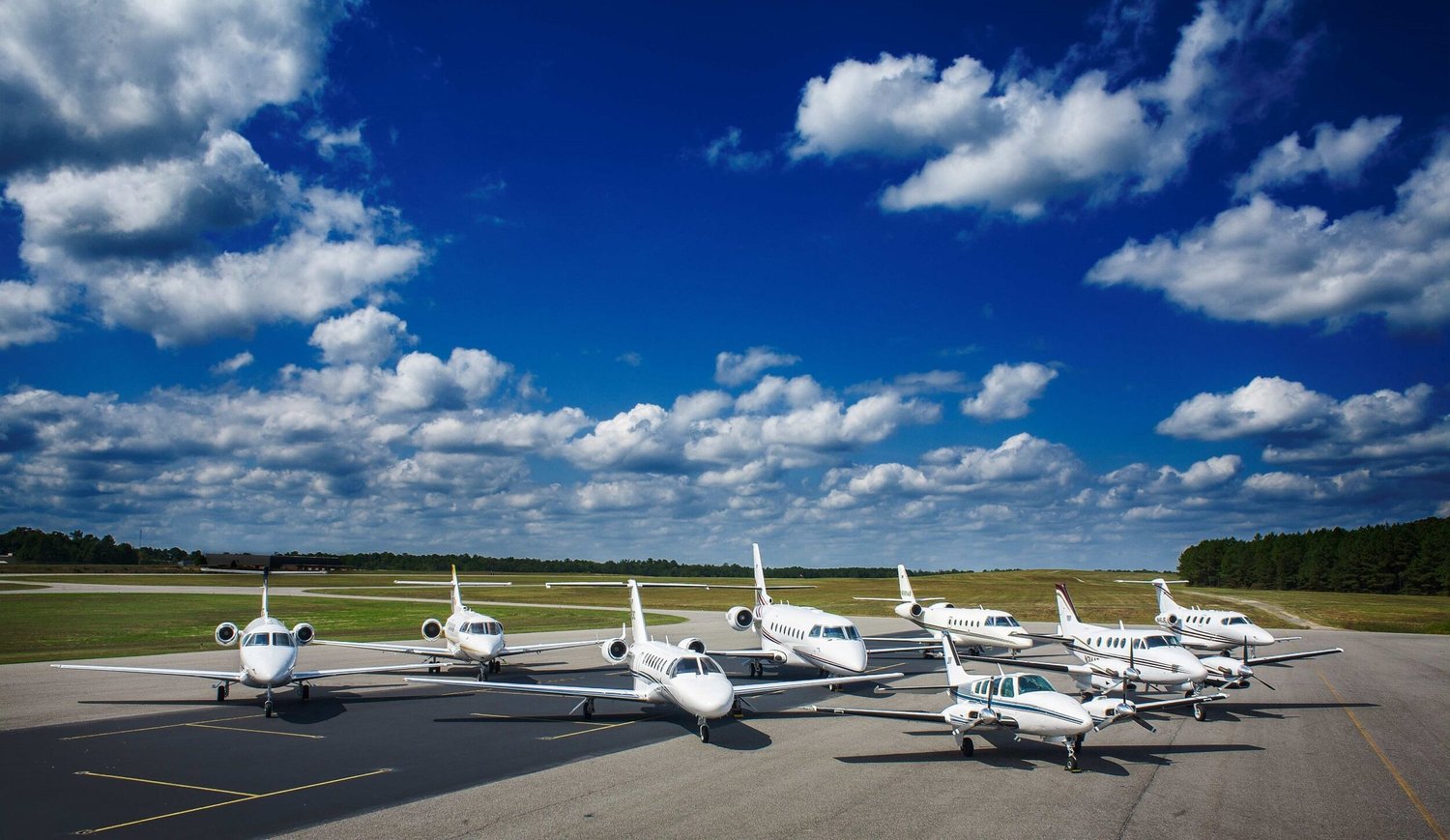 mutiple aircraft on runway with blue sky overhead